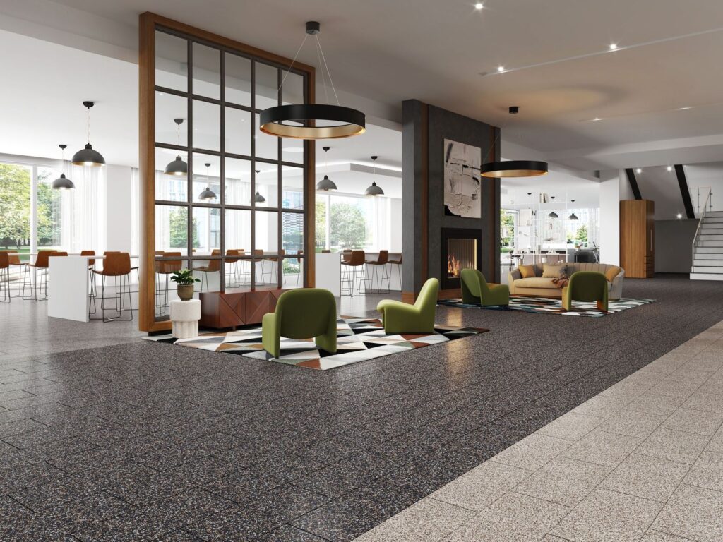 Modern lounge area featuring stylish green chairs and a cozy sofa, with a dining space in the background and large windows allowing natural light.